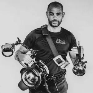 Photographer Michael Moore in Aruba, fully equipped with underwater camera gear, preparing for an underwater portrait photoshoot in a crystal-clear pool.